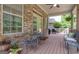 Inviting covered patio with brick surround, seating for 4, and wooded view at 185 Platinum Ridge Pt, Fayetteville, GA 30215