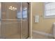 This bathroom features a glass-door walk-in shower with tile surround, alongside a window and decorative lighting at 185 Platinum Ridge Pt, Fayetteville, GA 30215