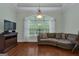 Comfortable sitting room features hardwood floors, a sectional sofa, television, and large windows for natural light at 185 Platinum Ridge Pt, Fayetteville, GA 30215