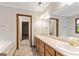Bathroom with double sink vanity, large mirror, and doorway leading to another room at 215 Longwood Dr, Jonesboro, GA 30236