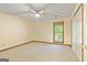 This is a large bedroom with carpet, a window, closet, and a ceiling fan at 215 Longwood Dr, Jonesboro, GA 30236