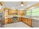 This sunlit kitchen has oak cabinets, stainless appliances, quartz countertops, and tile floors at 215 Longwood Dr, Jonesboro, GA 30236