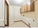 Functional laundry room with upper cabinets, tiled floor, and washer/dryer hookups at 215 Longwood Dr, Jonesboro, GA 30236