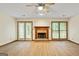 Bright living room featuring wood floors, fireplace, ceiling fan, and doors to the back patio at 215 Longwood Dr, Jonesboro, GA 30236