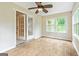 This is a sunroom with three windows, wood-look flooring, and a ceiling fan at 215 Longwood Dr, Jonesboro, GA 30236