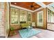Relaxing covered back porch featuring brick siding, comfortable seating, and a charming ceiling fan at 5130 Pratt Sw St, Covington, GA 30014