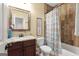 Bathroom with a vanity, toilet, mirror, and shower with birds on the curtain at 5130 Pratt Sw St, Covington, GA 30014