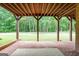 Covered patio with brick flooring, wood supports, and a view of the yard at 5130 Pratt Sw St, Covington, GA 30014
