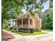Angle view of brick home featuring a spacious front porch and manicured yard at 5130 Pratt Sw St, Covington, GA 30014