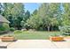 Spacious backyard showcasing manicured lawn, mature trees, and a retaining wall at 260 Bonnie Ln, Fayetteville, GA 30215