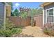 Cozy backyard area with gravel, mature trees, and a wooden privacy fence with arbor at 260 Bonnie Ln, Fayetteville, GA 30215