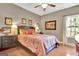 Cozy bedroom with wood floors, patterned bedding, and natural light from the window at 260 Bonnie Ln, Fayetteville, GA 30215