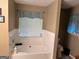A bathroom featuring a large soaking tub, a window, and a shower at 8519 Glenwoods Dr, Riverdale, GA 30274