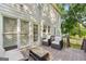 A wooden back deck features cushioned seating, a glass table, and access to the house, perfect for outdoor lounging at 7505 Brookwood Way, Cumming, GA 30041