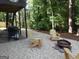 Backyard entertainment area with a grill, seating and a fire pit surrounded by lush trees at 7505 Brookwood Way, Cumming, GA 30041