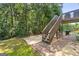 The walkout basement patio features a BBQ, a fire pit, and stairs to the deck at 7505 Brookwood Way, Cumming, GA 30041