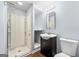 Modern bathroom with a glass enclosed shower and a vanity with black cabinets and bright lighting at 7505 Brookwood Way, Cumming, GA 30041