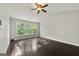 Spacious bedroom with hardwood floors, ceiling fan, and a large window for natural light at 7505 Brookwood Way, Cumming, GA 30041