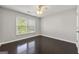 Cozy bedroom with hardwood floors, a ceiling fan, and a window with natural light at 7505 Brookwood Way, Cumming, GA 30041