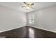 Empty bedroom with dark hardwood floor, ceiling fan, and natural light at 7505 Brookwood Way, Cumming, GA 30041