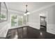 Bright dining room with wainscoting, natural light, dark hardwood floors and modern chandelier at 7505 Brookwood Way, Cumming, GA 30041