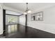 Light filled dining room with dark trim, hardwood floors, decorative mirror and modern chandelier at 7505 Brookwood Way, Cumming, GA 30041