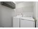 Functional laundry room with washer, dryer, overhead cabinet, and wire shelving at 7505 Brookwood Way, Cumming, GA 30041