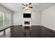 Bright living room features a fireplace, large windows, and sleek dark hardwood flooring at 7505 Brookwood Way, Cumming, GA 30041