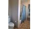 Bathroom with a blue shower curtain, a toilet, and a tiled floor at 522 Blue Mountain Rise, Canton, GA 30114
