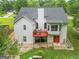 Back exterior of a two-story home, featuring a deck, patio, and spacious backyard with mature trees at 52 Cherub Ln, Sharpsburg, GA 30277