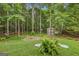 Backyard with mature trees, shed, firepit, and lush greenery, offering a private outdoor space at 52 Cherub Ln, Sharpsburg, GA 30277
