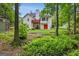 View of backyard featuring a two-story home, deck, and mature trees, creating a peaceful retreat at 52 Cherub Ln, Sharpsburg, GA 30277