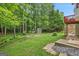 Backyard features mature trees, shed, firepit, and lush greenery, offering a private outdoor space at 52 Cherub Ln, Sharpsburg, GA 30277