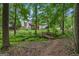 Backyard featuring mature trees, lush greenery, and a charming bridge, creating a private oasis at 52 Cherub Ln, Sharpsburg, GA 30277