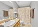 Bathroom with floral shower curtain, neutral-toned walls and vanity with integral sink and ample lighting at 52 Cherub Ln, Sharpsburg, GA 30277