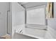 Bright bathroom featuring a white soaking tub under a window with blinds at 52 Cherub Ln, Sharpsburg, GA 30277