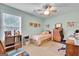 Bedroom featuring a window, ceiling fan, and cozy decor with a chair and desk at 52 Cherub Ln, Sharpsburg, GA 30277