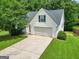 Front exterior of a home with a two-car garage, driveway, and well-maintained lawn at 52 Cherub Ln, Sharpsburg, GA 30277