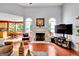 Open-concept living room with a fireplace, hardwood floors, and a view into the adjacent dining area at 52 Cherub Ln, Sharpsburg, GA 30277