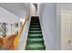 Carpeted staircase features a wooden handrail and leads to a bright, upper level at 52 Cherub Ln, Sharpsburg, GA 30277