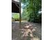 Backyard view from under deck showing a pine straw groundcover and mature trees along a wooden fence at 375 Sapphire Bnd, Riverdale, GA 30296