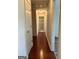A hallway with multiple doors and wood floors leads to a bathroom with a patterned shower curtain at 375 Sapphire Bnd, Riverdale, GA 30296