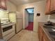 Kitchen with wood cabinets, white appliances, linoleum flooring, and view into another room at 375 Sapphire Bnd, Riverdale, GA 30296
