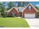 Charming brick home featuring a manicured lawn, an attached two-car garage, and mature landscaping at 1010 Capella Creek Way, Grayson, GA 30017