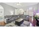Open concept living room with a large sectional sofa, hardwood floors and decorative arched doorways at 1010 Capella Creek Way, Grayson, GA 30017