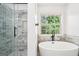 Relaxing bathroom space featuring a soaking tub, walk-in shower with marble tile and niche at 2580 Star Ln, Decatur, GA 30034