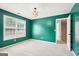 A bedroom featuring light-colored carpet, green walls, a geometric light fixture, and natural light at 2580 Star Ln, Decatur, GA 30034