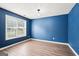 Cozy bedroom with blue walls, wood flooring, and a large window that allows natural light to flood in at 2580 Star Ln, Decatur, GA 30034
