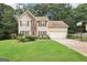 Traditional two-story home with a well-kept lawn, attached garage, and manicured landscaping at 2580 Star Ln, Decatur, GA 30034