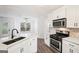 Bright kitchen with stainless steel appliances, white cabinets, modern hardware, wood look flooring and adjacent breakfast nook at 2580 Star Ln, Decatur, GA 30034